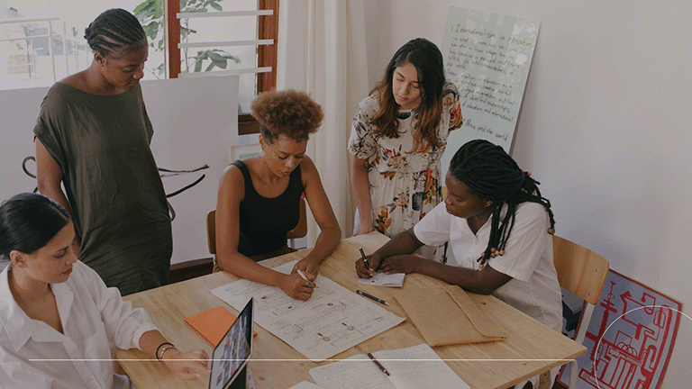 A group of people working on UI/UX design at a table